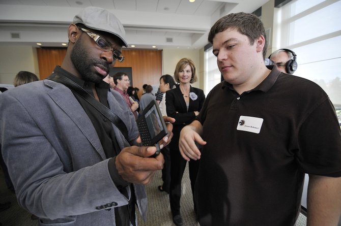 deaf-blind man checking out a mobile phone application with the graduate student who designed it